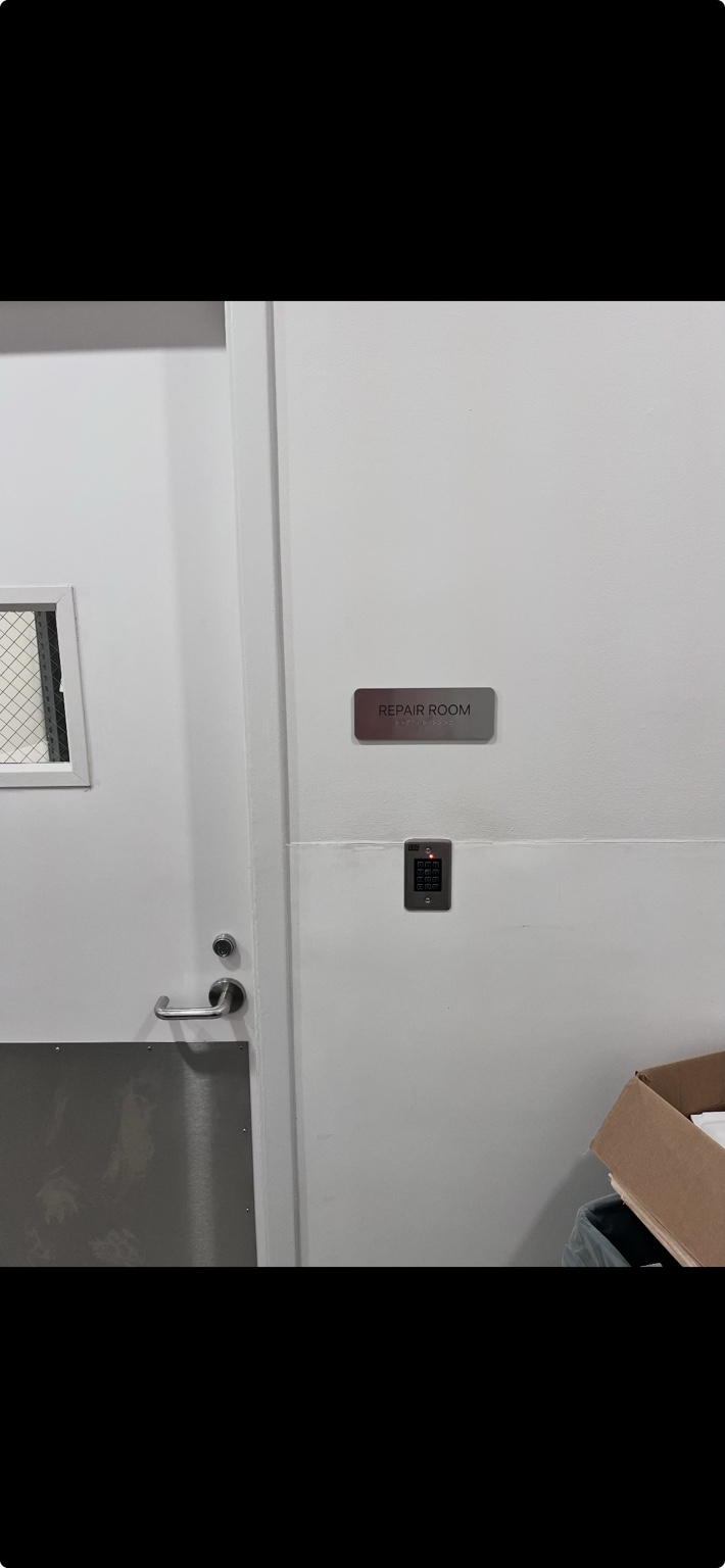 Repaired commercial door hardware with installed room signage