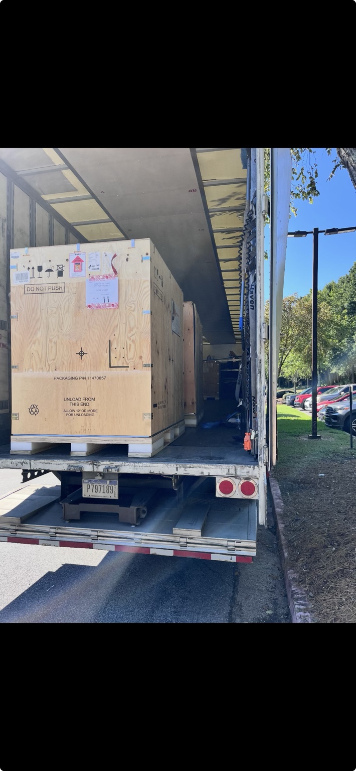 Large crated specialty equipment prepared for unloading from a truck